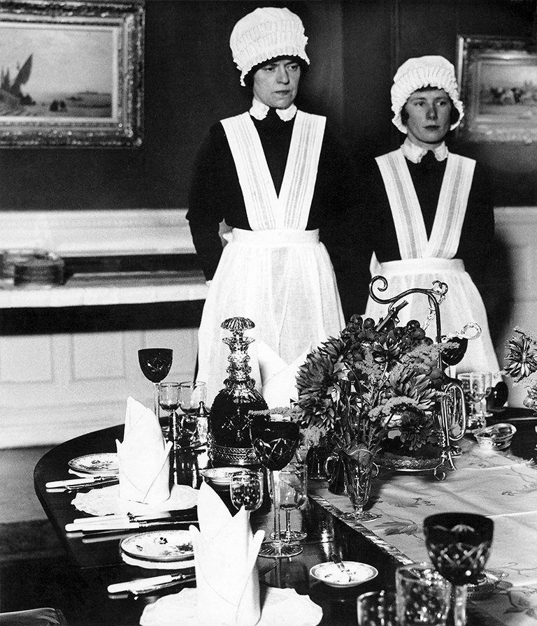 Sirvienta y sirvienta segunda preparadas para servir la cena - Bill Brandt